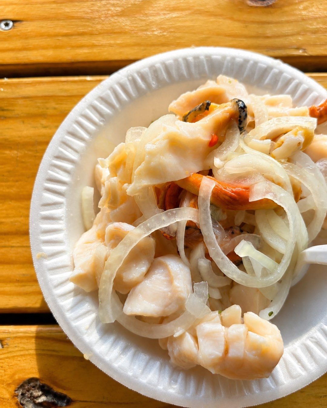 A plate of fresh conch salad with onion and lime.